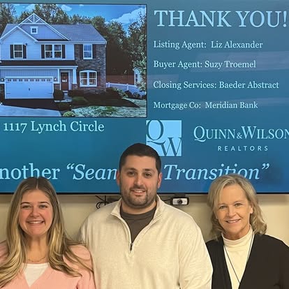 Three people celebrating a Quinn & Wilson real estate closing