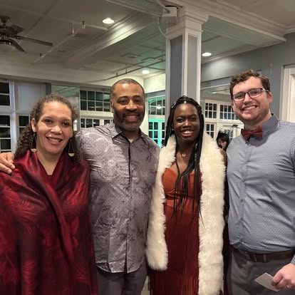 Four people smiling together at a Quinn & Wilson community event